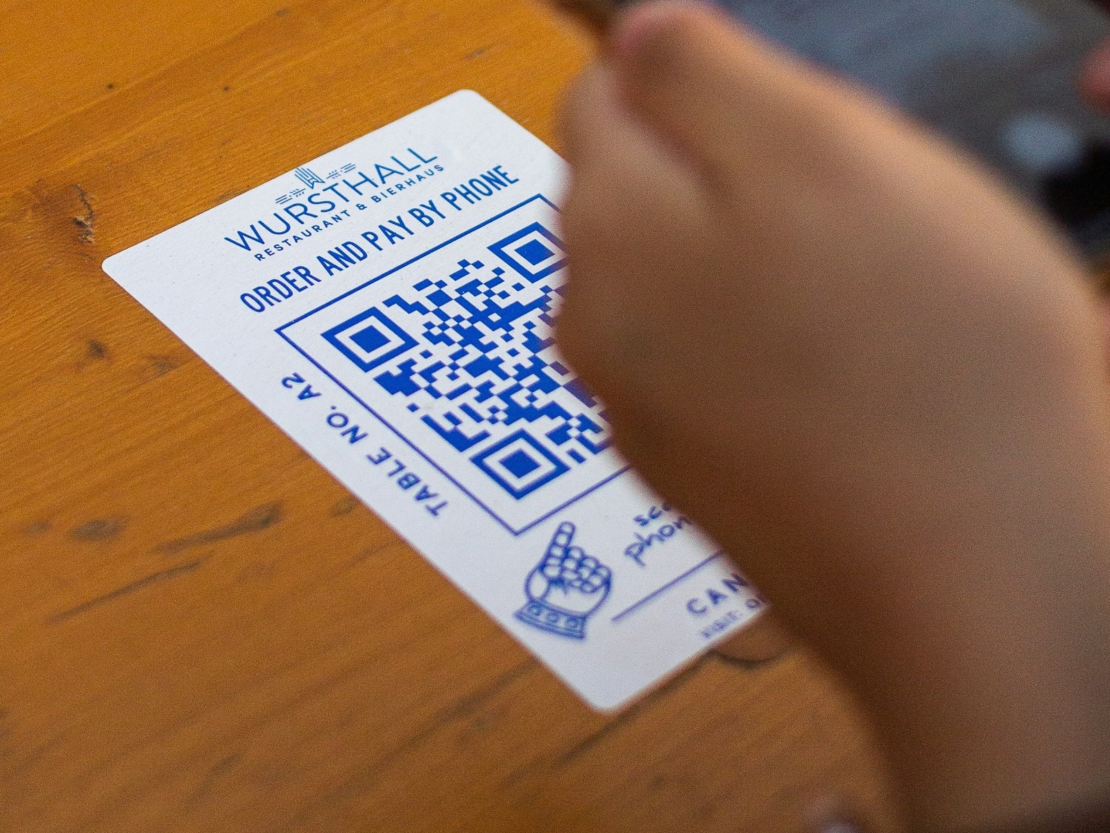 QR-code information card being scanned by a smartphone in a hospitality setting.