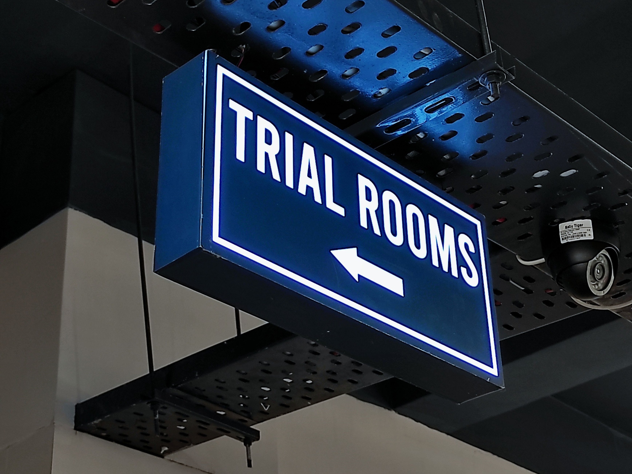 Illuminated Trial Rooms directional sign used as a retail component within a commercial interior.