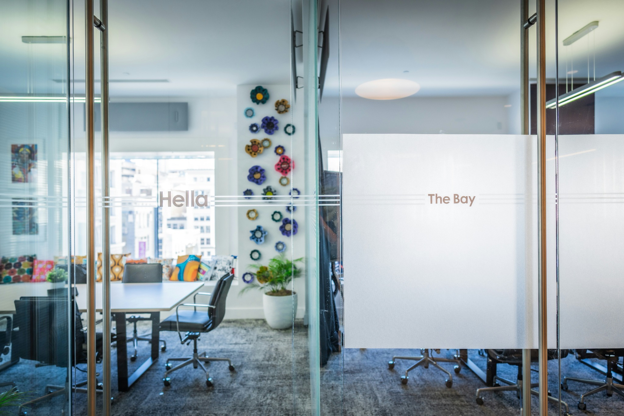 Corporate workplace branding with frosted glass graphics applied to meeting-room doors in a modern office.