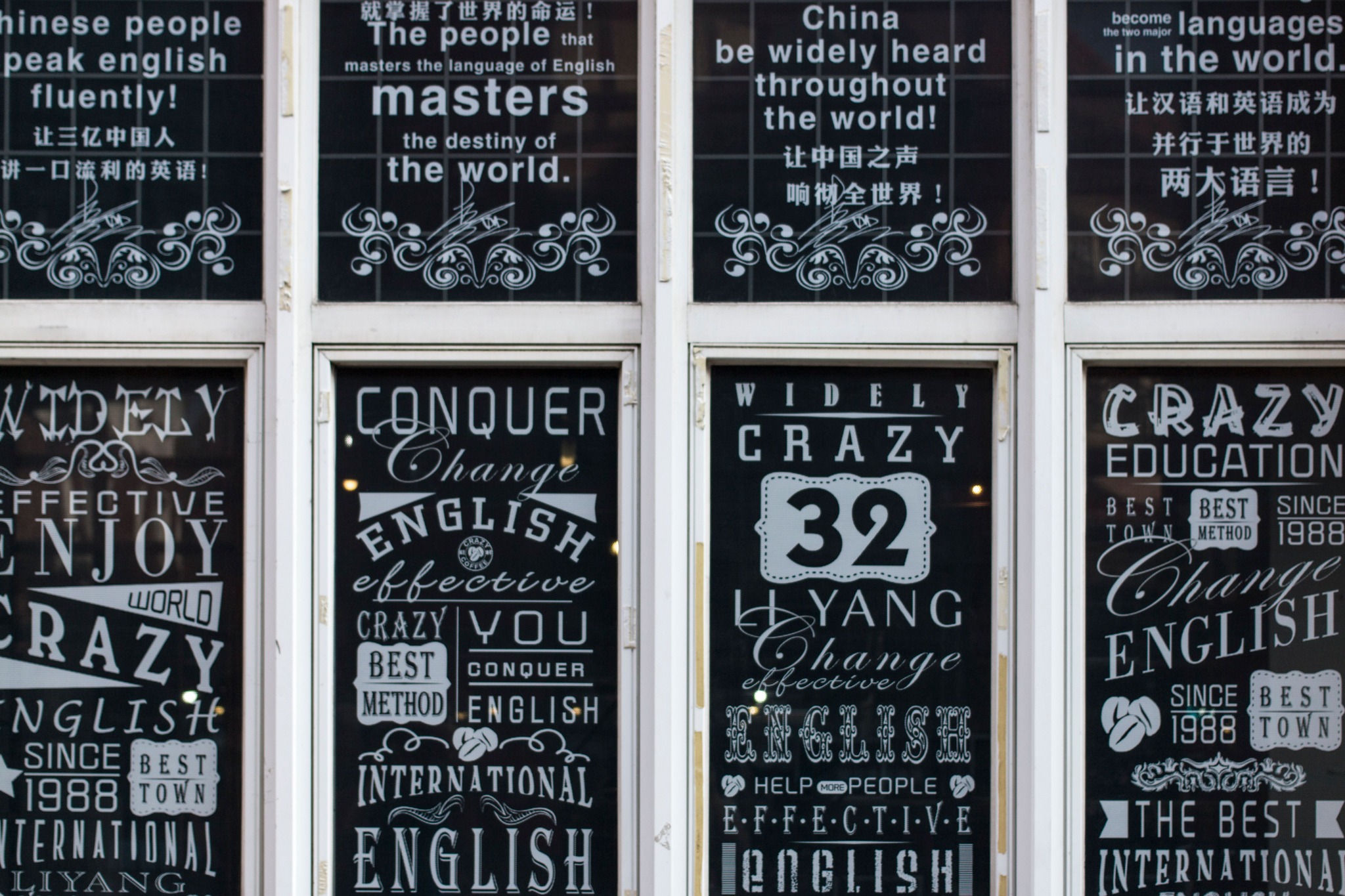 Typographic printed window graphics applied across a glazed commercial facade, demonstrating large-format digital printing for branded surfaces.