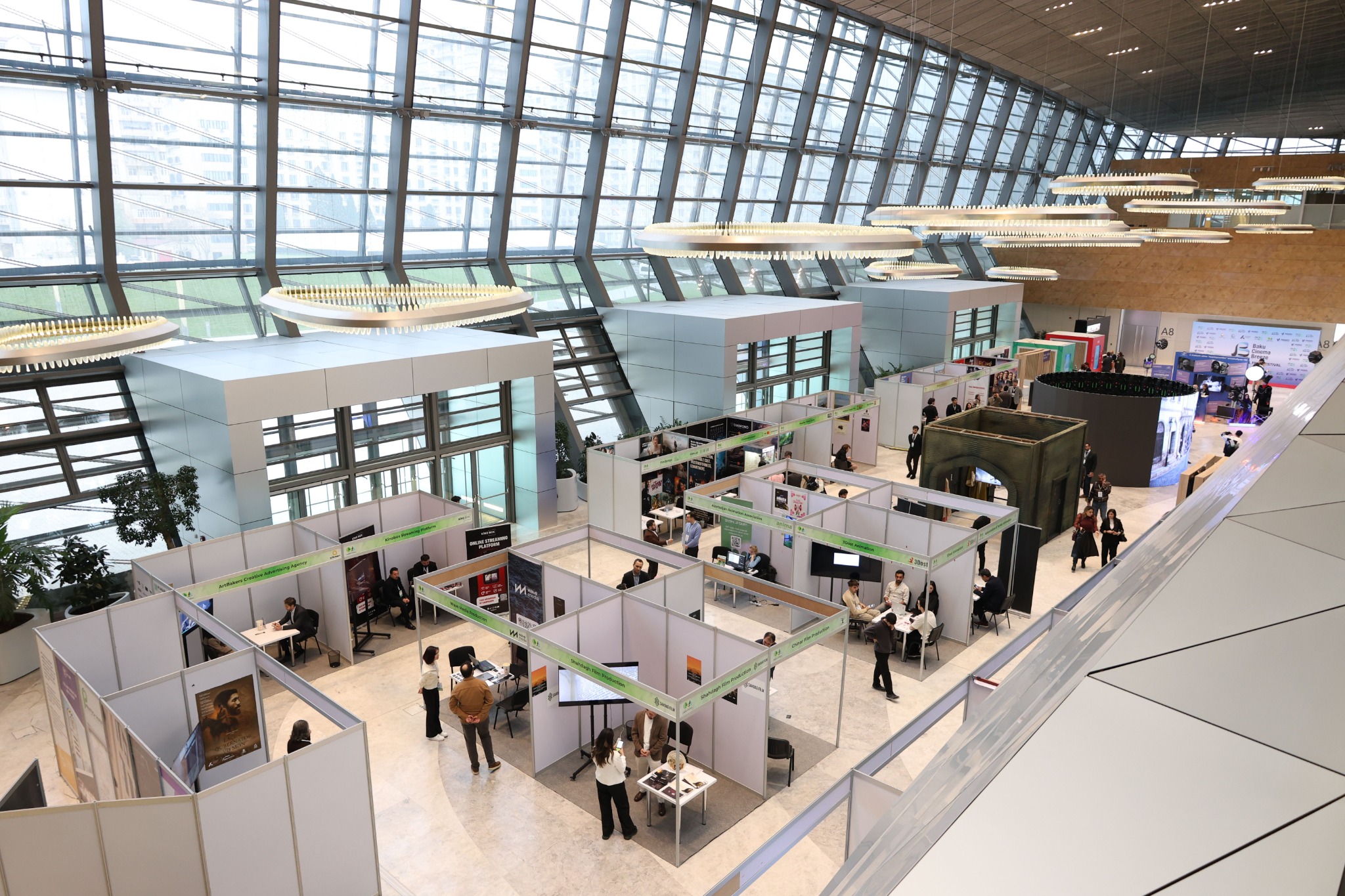 Large exhibition environment with modular booths, branded displays and visitor circulation across an event venue.