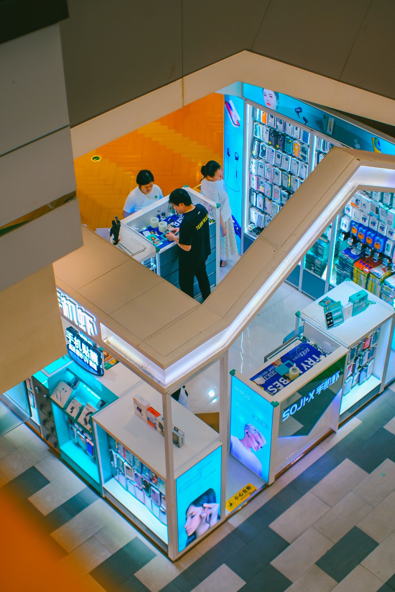 Illuminated retail-style exhibition kiosk with integrated product displays, counters and branded lightbox panels.