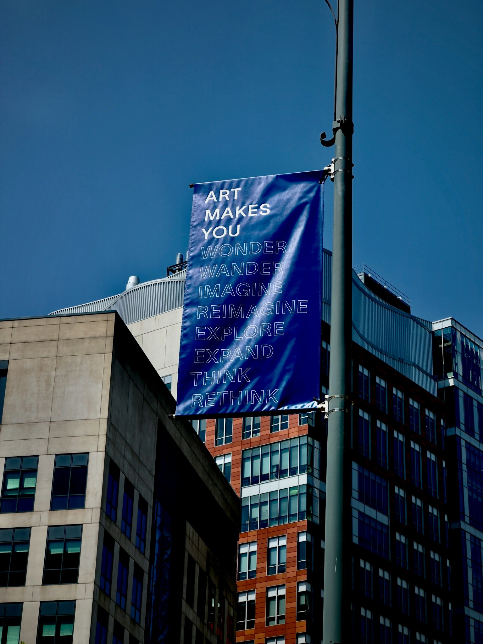 Large branded fabric banner installed on an urban display pole.