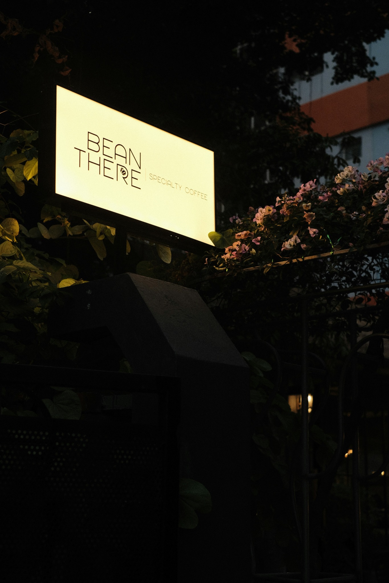 Illuminated lightbox sign glowing in an evening commercial setting.