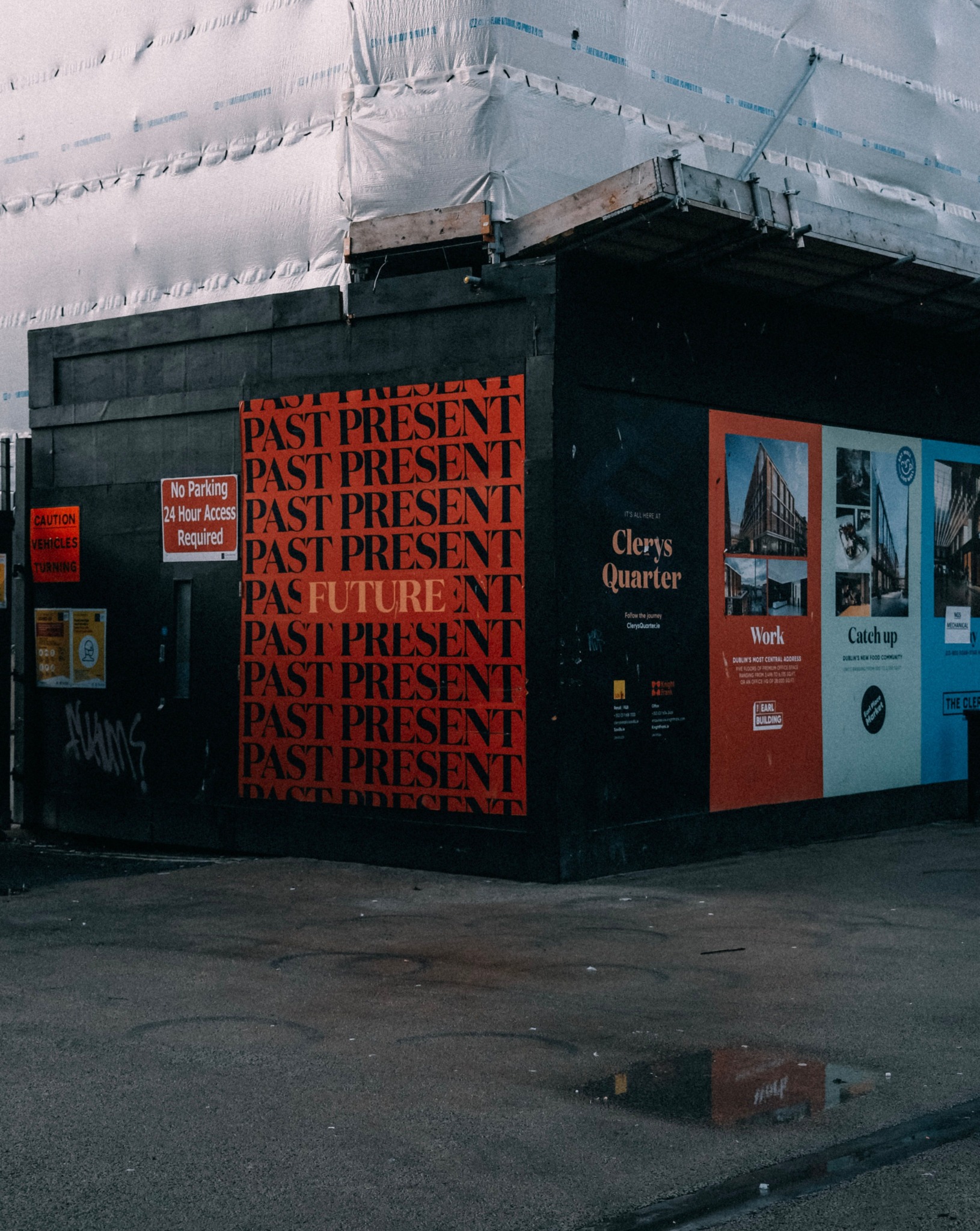 Large-format campaign graphics applied to a construction-site hoarding, creating strong street-level visual presence within the built environment.