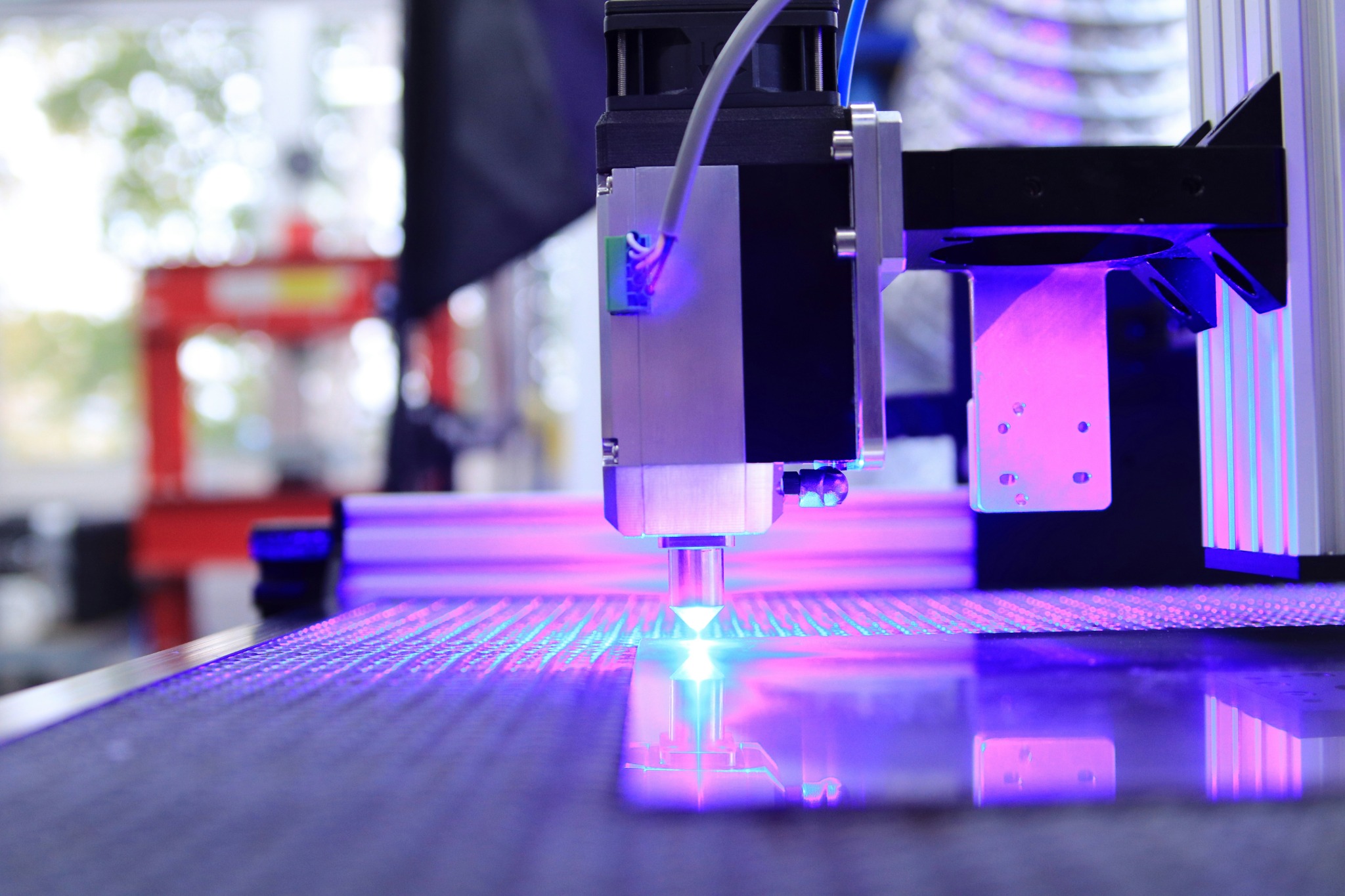 Precision production equipment working over a material surface in a modern fabrication environment