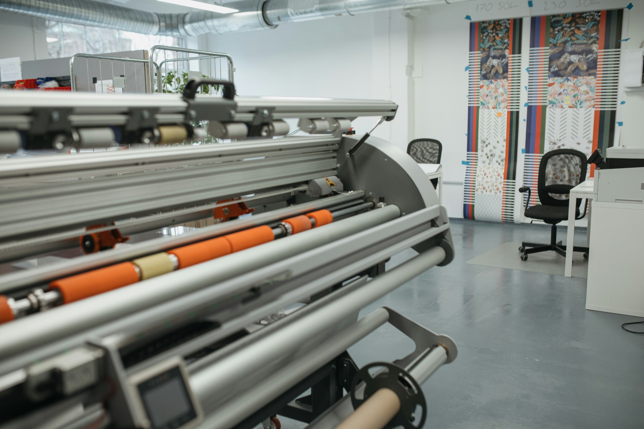 Large-format production machinery in a commercial print workshop, representing upcoming capabilities.