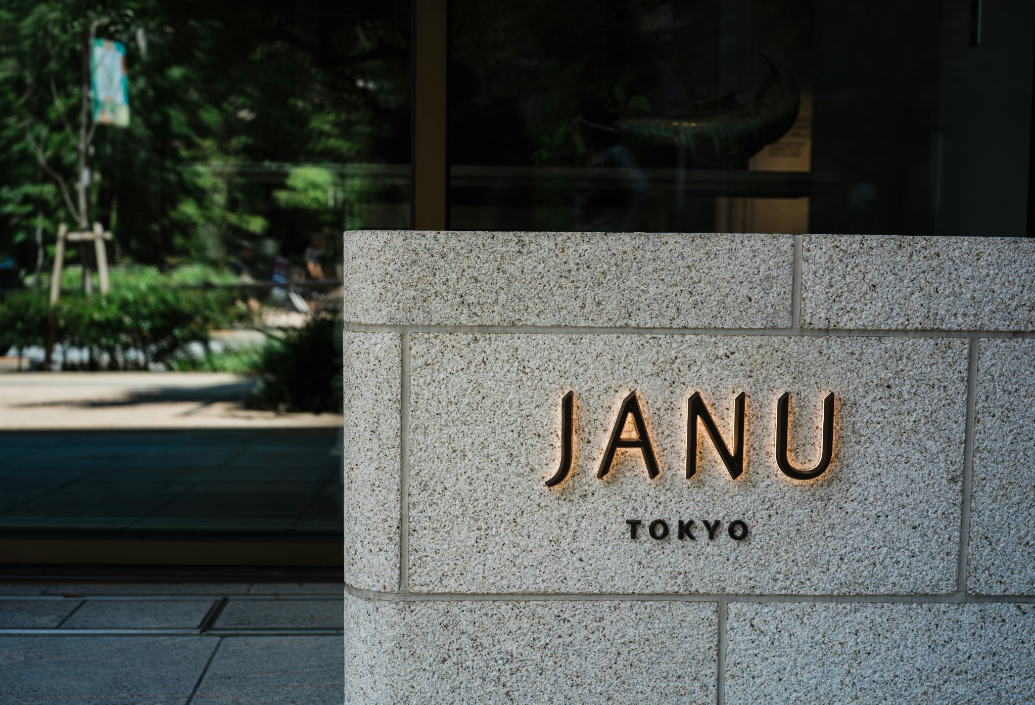 Close-up of refined sign installation details with illuminated lettering on stone.